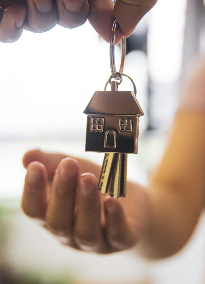 A person handing house key to another person
